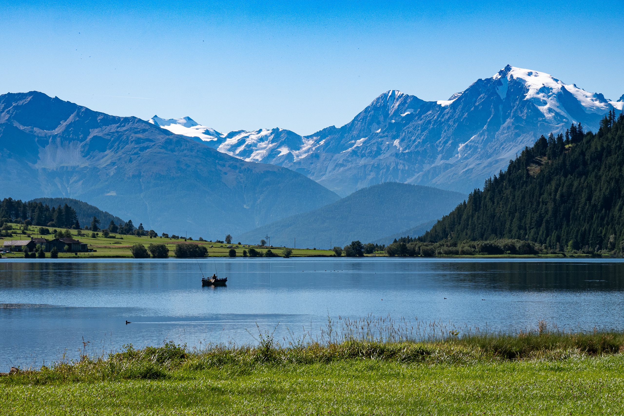 Fischerboot auf dem Haidersee vor dem verschneiten Ortler